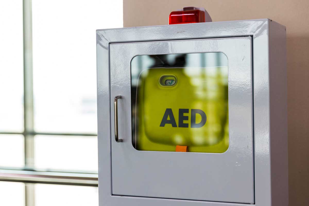 Wall-mounted AED cabinet with red alarm light
