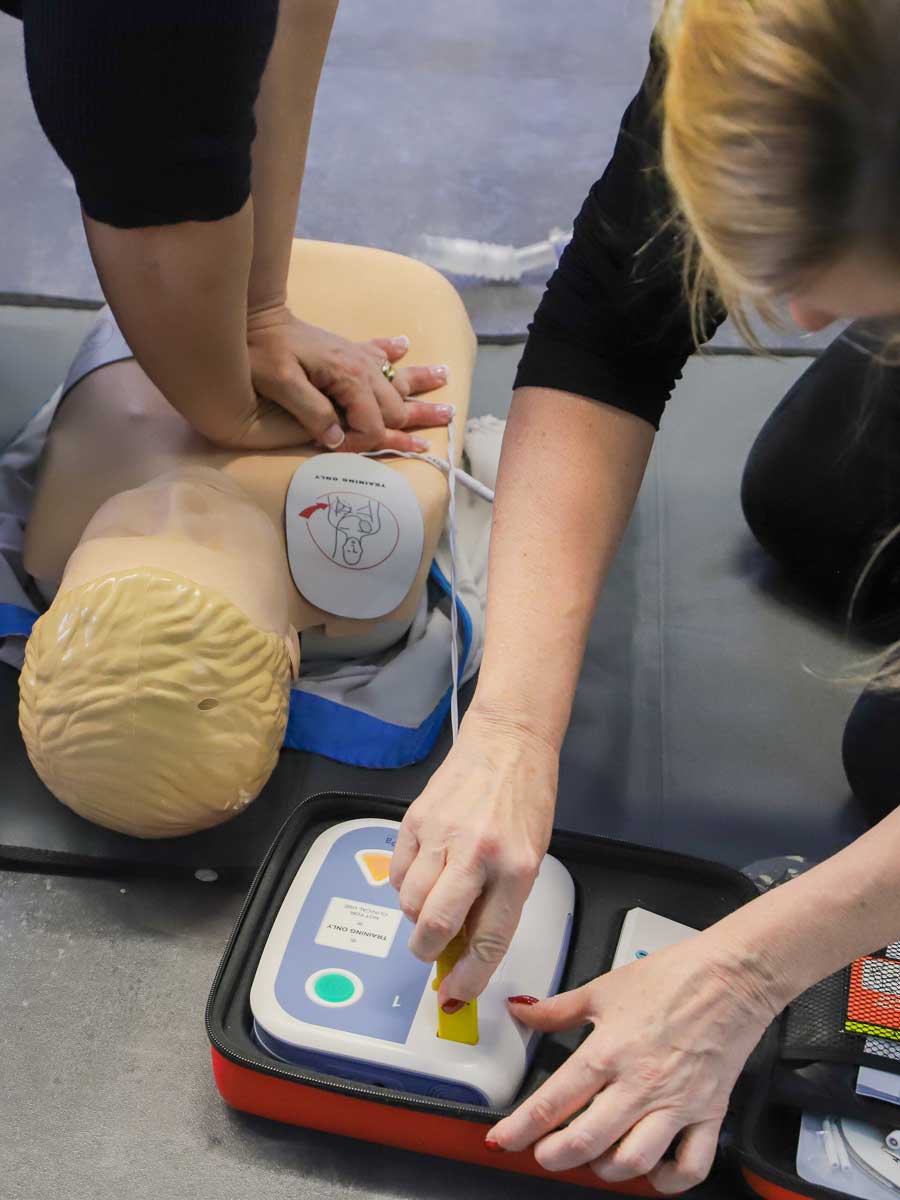 CPR training on mannequin with AED defibrillator