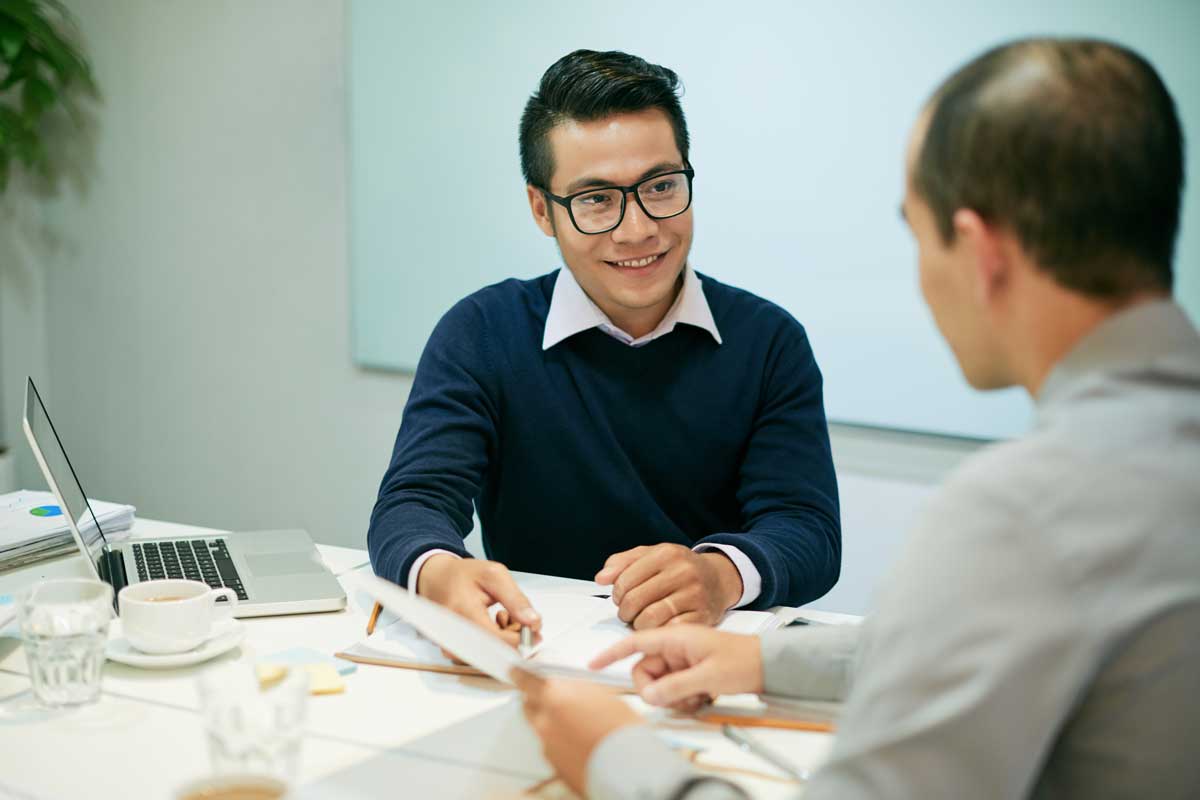 Business meeting with document exchange at office desk