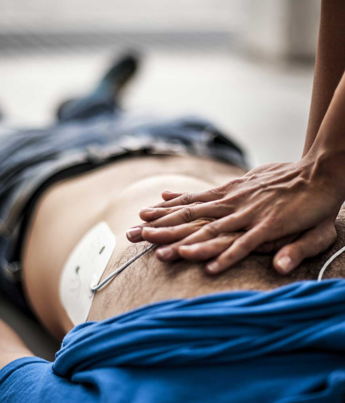 Person performing CPR with defibrillator pads attached